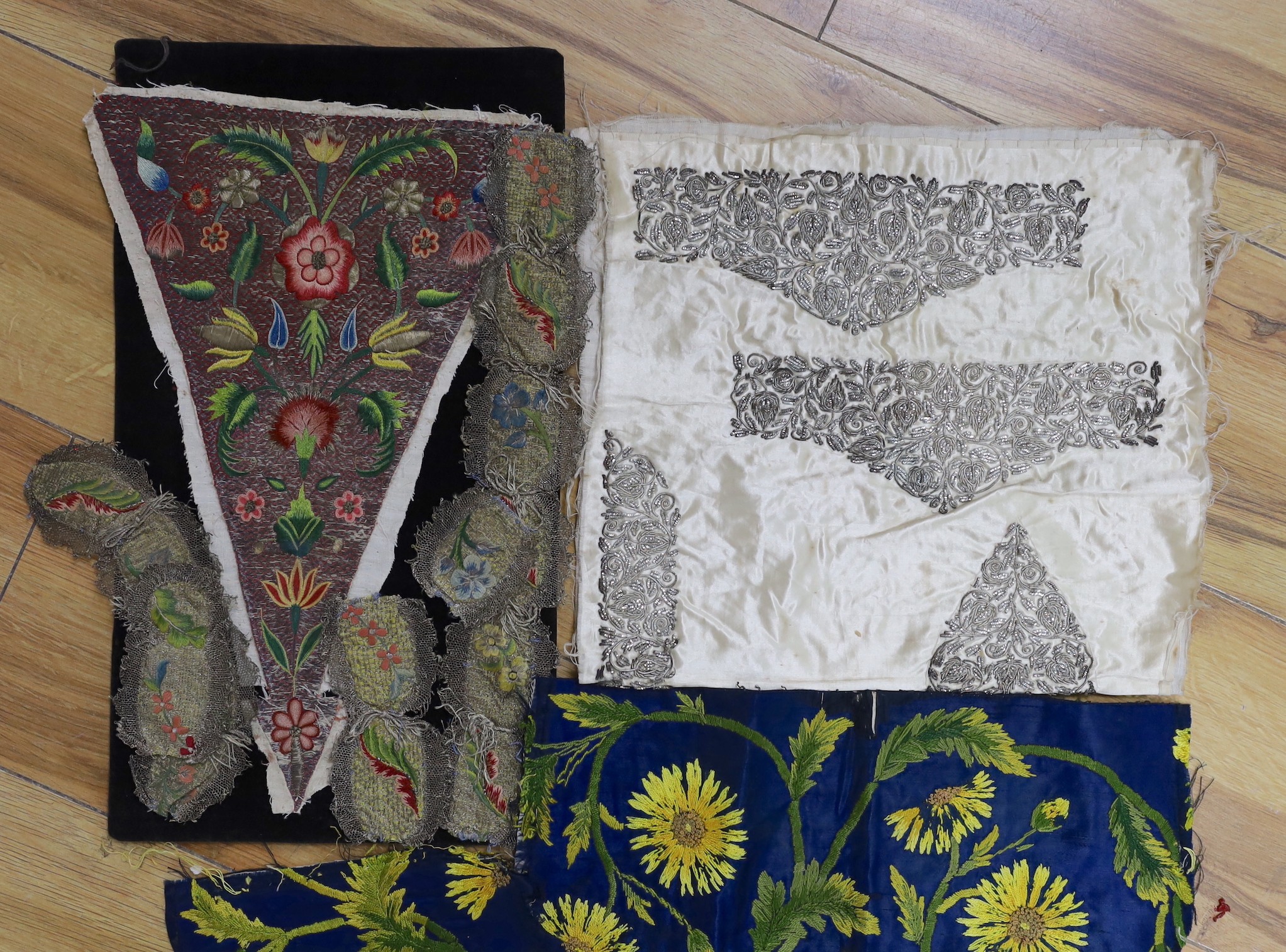 An 18th century embroidered dress front and a similar length of embroidered trimming, together with metallic thread and other later embroidered panels